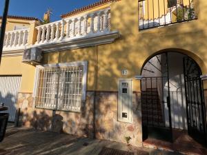 a yellow building with a door and a balcony at Gibralfaro Alojamiento Turístico cerca de la playa in Málaga