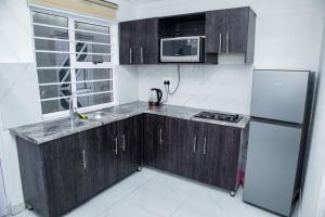 a kitchen with wooden cabinets and a sink and a refrigerator at one bedroom apartment A1 in Cape Town