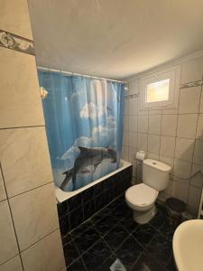 a bathroom with a dolphin shower curtain and a toilet at Peaceful house in Alexandroupoli +11 photos
