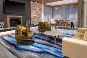a living room with furniture and a dining room at Fairfield Inn & Suites by Marriott Queensbury Glens Falls/Lake George in Queensbury