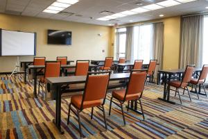 a conference room with tables and chairs and a white screen at Fairfield Inn & Suites by Marriott Madison Verona in Verona +14 photos