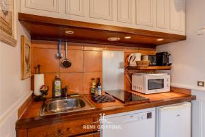 una piccola cucina con lavello e microonde di Key West - charming studio ON the port of Honfleur - Superb 360 view a Honfleur Altre 6 foto