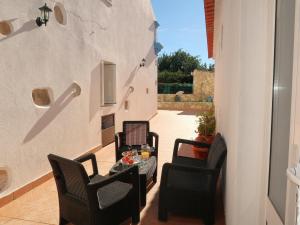 a patio with chairs and a table and a wall at Ferienhaus Casa Limoeiro by fewo-plan ESTO101 an der Algarve in Azinheiro