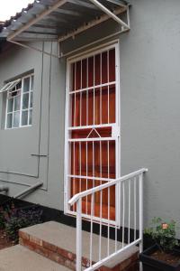 ein Haus mit einem Fenster mit einer weißen Schiene in der Unterkunft Angel Cottage in Tzaneen
