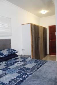 ein Schlafzimmer mit einem Bett und einem Holzschrank in der Unterkunft Angel Cottage in Tzaneen