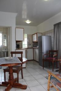 a kitchen with a table and a refrigerator at Angel Cottage in Tzaneen