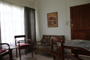 ein Wohnzimmer mit Tisch und Stühlen und einem Fenster in der Unterkunft Angel Cottage in Tzaneen