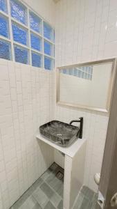 a white tiled bathroom with a sink and a window at Moon house Beach Hostel in Haad Rin +57 photos