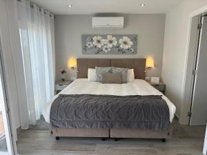 ラゴスにあるCasa Paula Apartmentsの大きなベッドと2つのナイトスタンドを備えた寝室