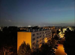 维勒班Spacious &nice apartment with balcony and parking的一座拥有黄色外墙和停车场的建筑