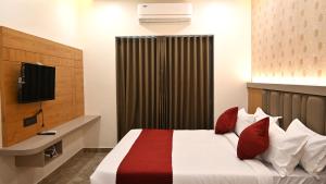 德瓦尔卡The Sky Comfort Hotel Mahi的配有床和电视的酒店房间