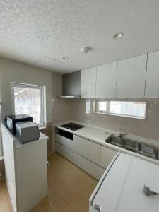 a kitchen with white cabinets and a sink at Niseko Yu Villa C in Niseko