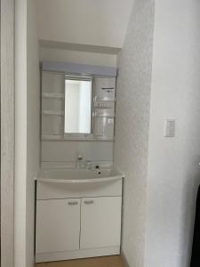 a white bathroom with a sink and a mirror at Niseko Yu Villa C in Niseko +15 photos