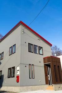 a large gray building with a red roof at Niseko Yu Villa C in Niseko