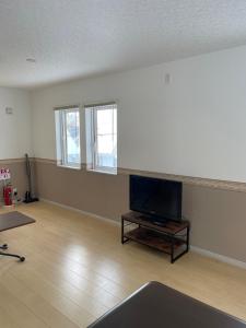 an empty living room with a flat screen tv at Niseko Yu Villa C in Niseko