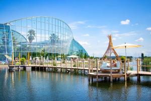 a person sitting in a chair on a pier with a building at Designer Apartment in Sinsheim Erstbezug 75 TV mit Netflix und offene Küche WeHome Premium in Sinsheim