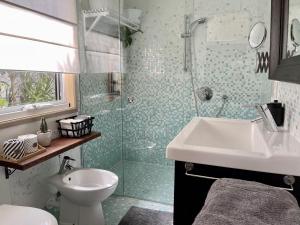a bathroom with a sink and a toilet and a shower at The White Cottage Byron Bay in Suffolk Park +55 photos