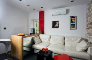 sala de estar con sofá blanco y mesa en Marinac City Center Apartments & Rooms, en Split