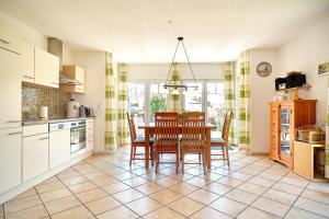 a kitchen and dining room with a table and chairs at Am Redensee in Fuhlendorf