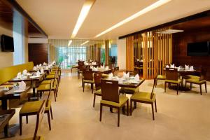 Un comedor con mesas y sillas en un restaurante. en Four Points by Sheraton Ahmedabad, en Ahmedabad