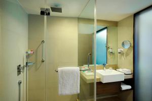 Un baño con lavabo y ducha con espejo. en Four Points by Sheraton Ahmedabad, en Ahmedabad