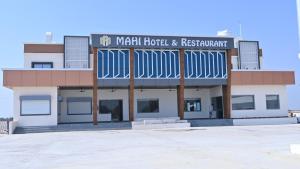 德瓦尔卡The Sky Comfort Hotel Mahi的一座建筑,上面有看酒店和餐厅的标志