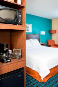a hotel room with a bed and a microwave at Fairfield Inn & Suites South Bend Mishawaka in South Bend