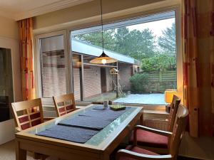 a dining room with a table and a large window at Küsten Koje in Sankt Peter-Ording +7 photos