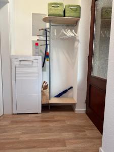 a refrigerator in a room with a shelf and a door at Küsten Koje in Sankt Peter-Ording