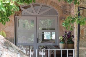 una puerta con una ventana en un muro de piedra en Masseria Abbracciavento - Private Pool by HDSalento, en Tricase 45 fotos más