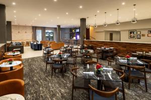 a restaurant with tables and chairs and a bar at Four Points by Sheraton Atlanta Airport West in Atlanta
