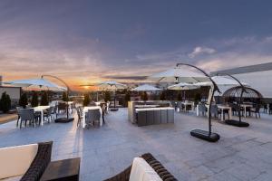 a patio with tables and umbrellas on top of a building at Four Points by Sheraton Atlanta Airport West in Atlanta