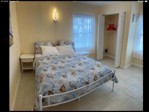 una camera da letto con un letto con un piumone blu di Charming 3 Bedroom 2 Bathroom and a lanai a Venice