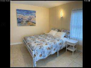 una camera da letto con un letto e un quadro sul muro di Charming 3 Bedroom 2 Bathroom and a lanai a Venice Altre 12 foto