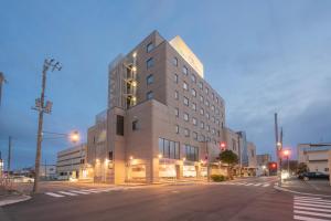 Un edificio alto en una calle de la ciudad por la noche. en Hotel Hakodate Royal Seaside BBH Hotel Group, en Hakodate