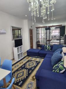 ケープタウンにあるTia Maria bachelor apartmentのリビングルーム(青いソファ、シャンデリア付)