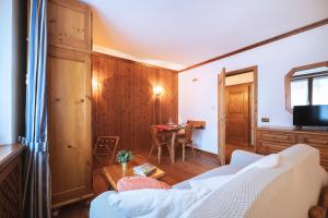 a living room with a couch and a table at GuestHost - Cortina Heart Retreat with Parking in Cortina dʼAmpezzo