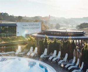 basen z leżakami i budynkiem w obiekcie Pension Restaurant Rosenberg w mieście Jennersdorf