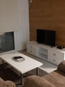 a living room with a tv and a white coffee table at Apartments Leo in Bar