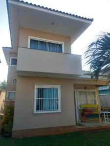 a house with a white cover on top of it at Chalé das Conchas in Cabo Frio