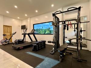 a gym with several tread machines in a room at Strutz Art Garden Resort in Bangued