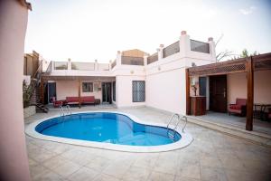 a house with a swimming pool in the yard at Andalusia Blue Beach Hurghada in Hurghada