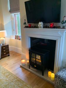 a living room with a fireplace with a television above it at Tower View Apartment in Carrick +6 photos