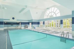 an indoor swimming pool with chairs and a swimming pool at Four Points by Sheraton Buffalo Grove in Buffalo Grove