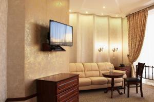 a living room with a couch and a tv on a wall at Harvest in Vinnytsya