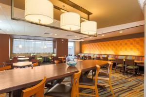a dining room with a large wooden table and chairs at Fairfield Inn & Suites by Marriott Alexandria in Alexandria +33 photos