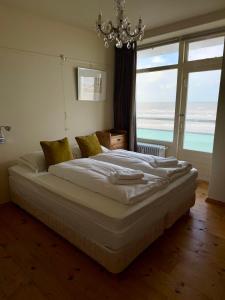 Un dormitorio con una cama con vista al mar. en Blue Bay Zandvoort, en Zandvoort 13 fotos más