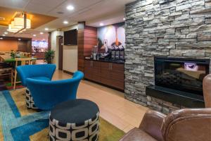 a lobby with a stone fireplace and blue chairs at Fairfield Inn Salt Lake City South in Murray