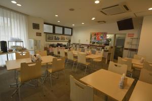 a restaurant with tables and chairs and a kitchen at Hotel Soleil in Iwaki