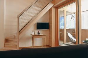 a room with a staircase with a table and a television at Ferienwohnung z'übrmello in Mellau